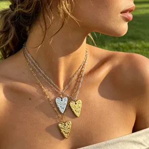 Layered stainless steel heart necklace with paperclip chains. Elegant gold and silver jewelry.
