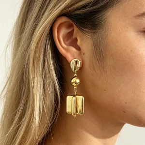 Close-up shot of gold geometric statement earrings featuring a shell top and chunky drops.