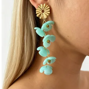 Detailed shot of trendy long resin flower earrings with gold metal top and blue petals.