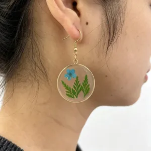 Resin dried flower plant leaf round pendant earrings detail closeup view, elegant style.