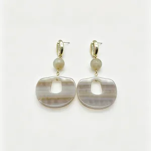 Boucles d'oreilles en résine chic avec clous coquillage or et pendentif rayé unique.