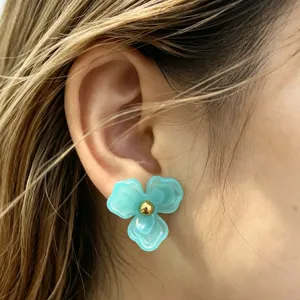 Detailed close-up of blue resin flower stud earrings, sweet floral design for daily wear.