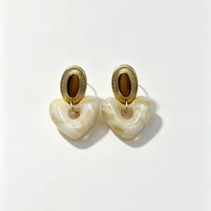 Detailed view of fashionable resin heart earrings with vintage gold stainless steel studs.