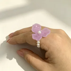 Gedetailleerd shot van paarse acryl bloemring met parels, Koreaanse frisse stijl.
