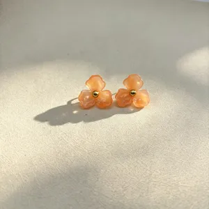 Chic peach resin flower stud earrings with gold bead center, sweet floral design.