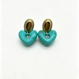 Detailed shot of trendy turquoise marble resin heart earrings with gold metal stud top component.