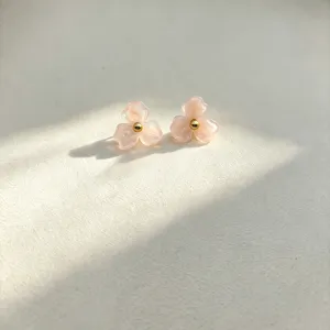 Detailed view of sweet pink resin flower stud earrings with a tiny central gold bead.