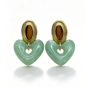 Close-up detail of green marbled resin hollow heart earrings with vintage gold oval top studs.