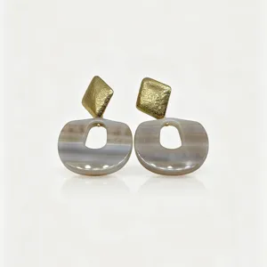Close-up detail view of retro geometric resin agate earrings with textured gold top piece.