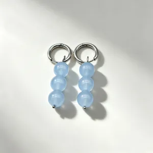 Detailed close-up of light blue natural stone beaded dangle hoop earrings with elegant silver metal.