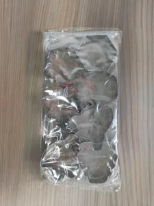Gedetailleerde detailopname van RVS koekvormen in een heldere plastic verpakking.