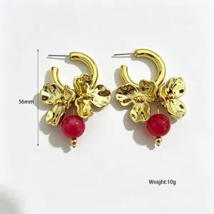 Exaggerated metal flower hoop earrings with red bead pendant, stylish statement jewelry.