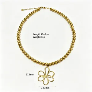 Gedetailleerde close-up van de gouden kralenketting met een unieke bloemhangertje.