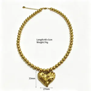 Gedetailleerd overzicht van de stijlvolle gouden kralenketting met een getextureerd hartje.
