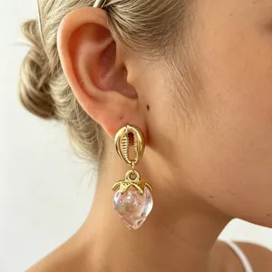 Gros plan détaillé des boucles d'oreilles pendantes fraise rose acrylique style ins doré.