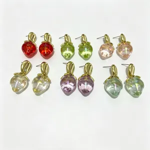 Boucles d'oreilles pendantes fraise en acrylique coloré avec détails dorés élégants.