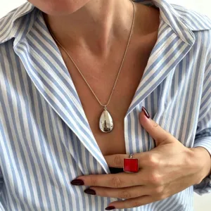 Elegant smooth teardrop pendant necklace and square ring detail view fashion jewelry.