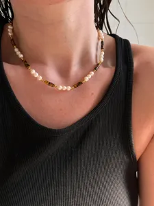 Close-up detail of the handmade beaded necklace featuring pearls and tiger's eye stones.