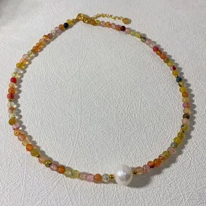 Detailed close-up of handmade beaded choker necklace with colorful natural stones and pearl pendant.
