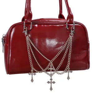 Detailansicht der roten Ledertasche mit gotischen Metall-Kreuzketten und mehrschichtigem Anhänger.