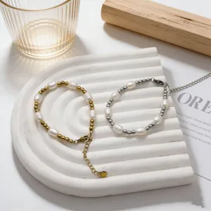 Elegante set di bracciali in perle d'acqua dolce naturali e acciaio, oro e argento.
