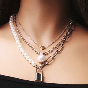 Multi-layer necklace featuring baroque pearls, metal chains, heart and lock pendants for women.