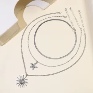 Detail shot of multi-layer silver necklace set featuring sun and starfish charms.