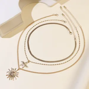 Close-up detail of multi-layer gold layered necklace with sun and starfish pendants.