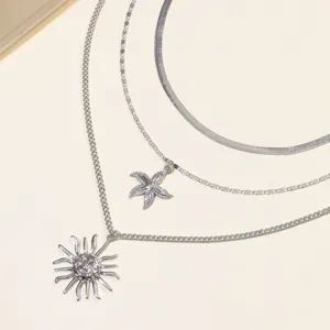 Layered silver sun starfish necklace detail shot showcasing intricate metal craftsmanship.