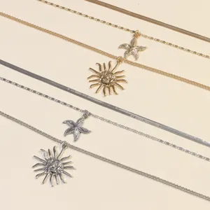 Close-up detail of multi-layered gold and silver sun and starfish pendant necklaces.