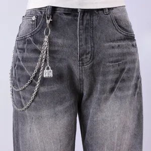Detailed view of grey washed denim jeans featuring a stylish silver metal chain accessory.