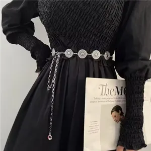 Detail view of silver metal waist chain with round filigree medallions and chains.