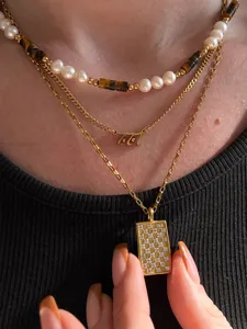 Boho layered necklace set with pearls, tiger's eye beads, and chic pendant designs.