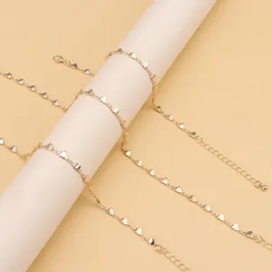 Gold-colored alloy anklet featuring dainty heart charms and adjustable extension chain.