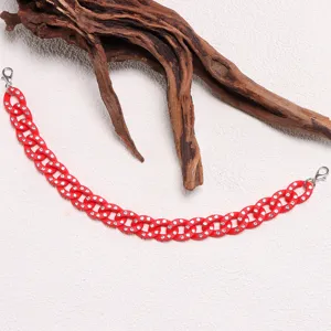 Close-up red rhinestone chain accessory, sparkling crystal charm for fashion hats and bags.
