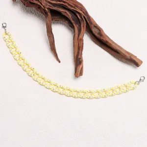 Close-up of sparkling rhinestone hat chain detail, stylish yellow decorative accessory.