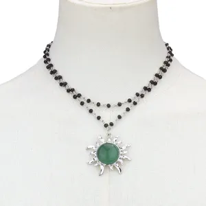 Double layer black beaded necklace with green sun pendant fashion jewelry detail shot.