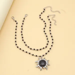 Close-up detail shot of the gothic style double layer black beaded sun pendant necklace.