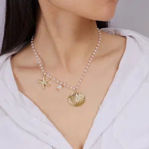 Elegant marine style pearl necklace featuring gold starfish and seashell pendant.