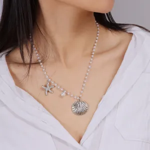 Close-up detail shot of the ocean style pearl necklace featuring a shell and starfish pendant.
