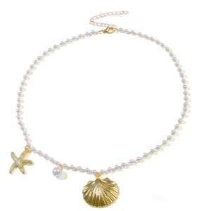 Gold seashell and starfish pearl necklace detail, ocean style clavicle chain close up.