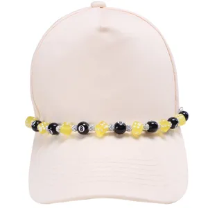 Cappellino da baseball con accessorio catena perle dadi e palla 8, dettaglio streetwear trendy.