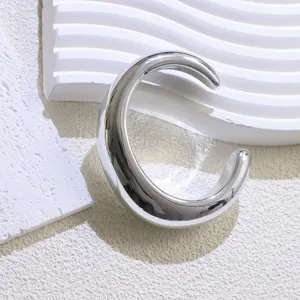 Silver wide open metal cuff bracelet minimalist fashion accessory close-up detail shot.