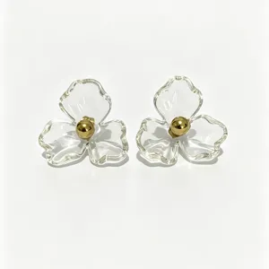 Clear resin flower stud earrings with gold ball center, elegant sweet floral jewelry detail.