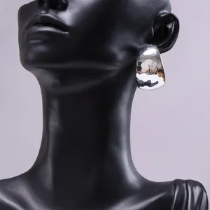 Close-up of the silver chunky hammered hoop earring detail, showcasing unique texture.