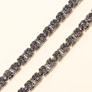 Λεπτομερές κοντινό πλάνο βαριάς μεταλλικής πλεγμένης αλυσίδας με περίπλοκο σχεδιασμό συνδέσμων.
