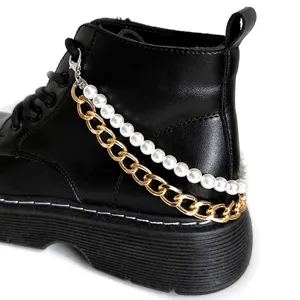 Classic black martin boots featuring a chic double layer pearl and gold chain accessory.