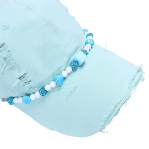 Detail van lichtblauwe versleten honkbalpet met blauwe dobbelstenen en glitter kralen.