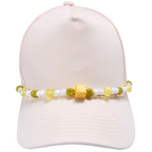 Close-up van beige honkbalpet met gedetailleerde accessoire van dobbelsteen kralen.