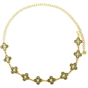 Detail view of the vintage gold chain belt featuring intricate clover motifs and turquoise stones.